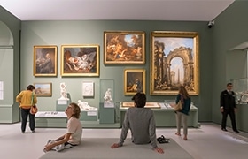Peoples sitting and enjoying paintings in art gallery